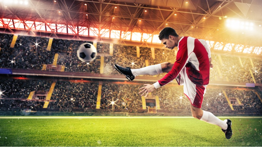 The image shows a soccer player kicking a ball on the pitch.