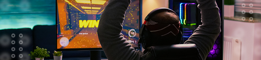 image shows a gamer celebrating in front of his computer