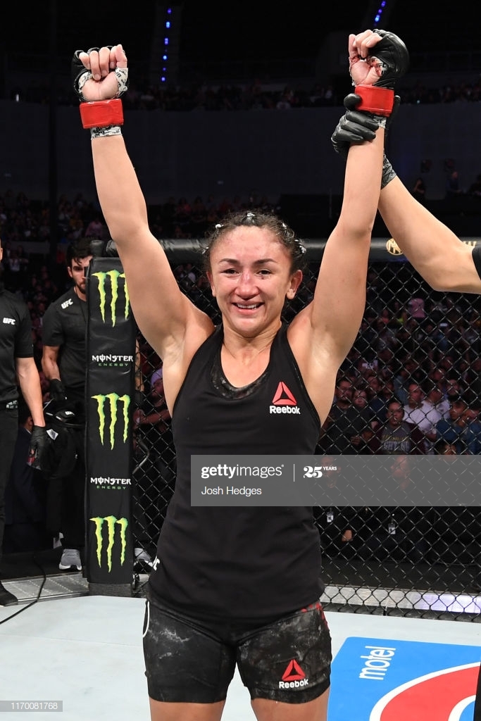 Carla Esparza holding her arms up in victory. Esparza vs Rodriguez.