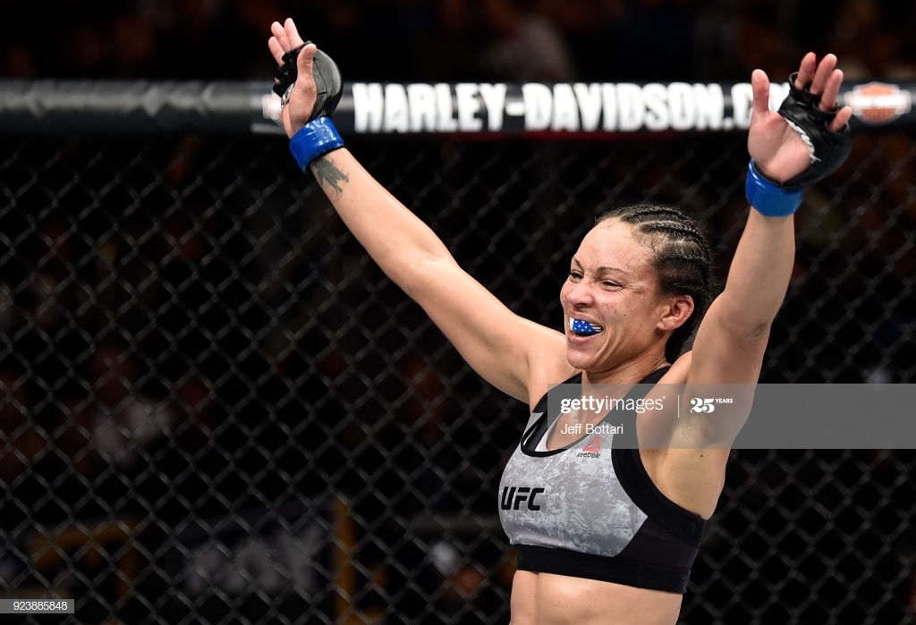 Marion Reneau holding her hands up in victory