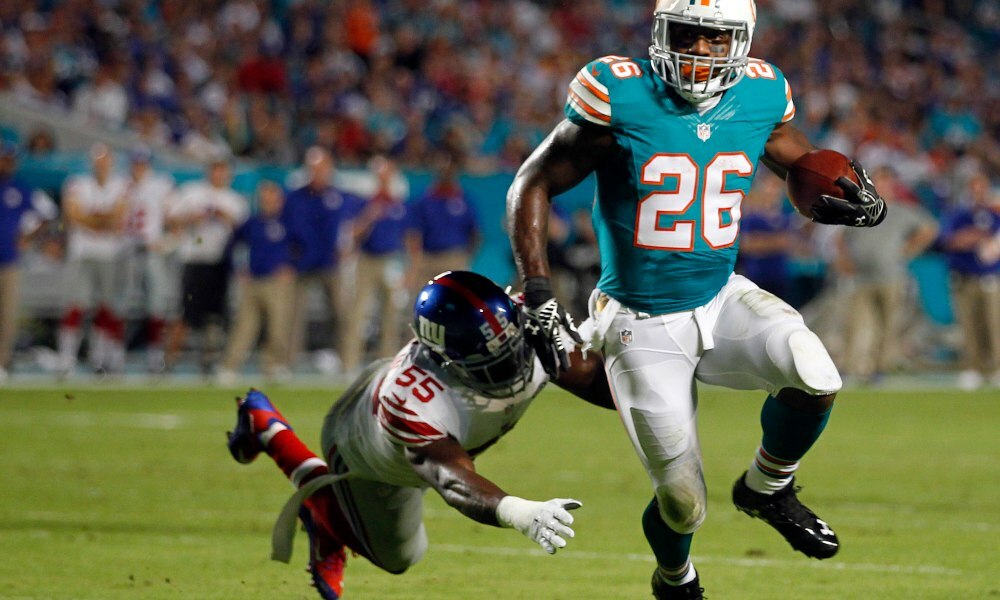 Miami Dolphins running back Lamar Miller (26) runs for a first down in the  third quarter against the Atlanta Falcons at Sun Life Stadium in Miami,  Florida, on Sunday, September 22, 2013. (